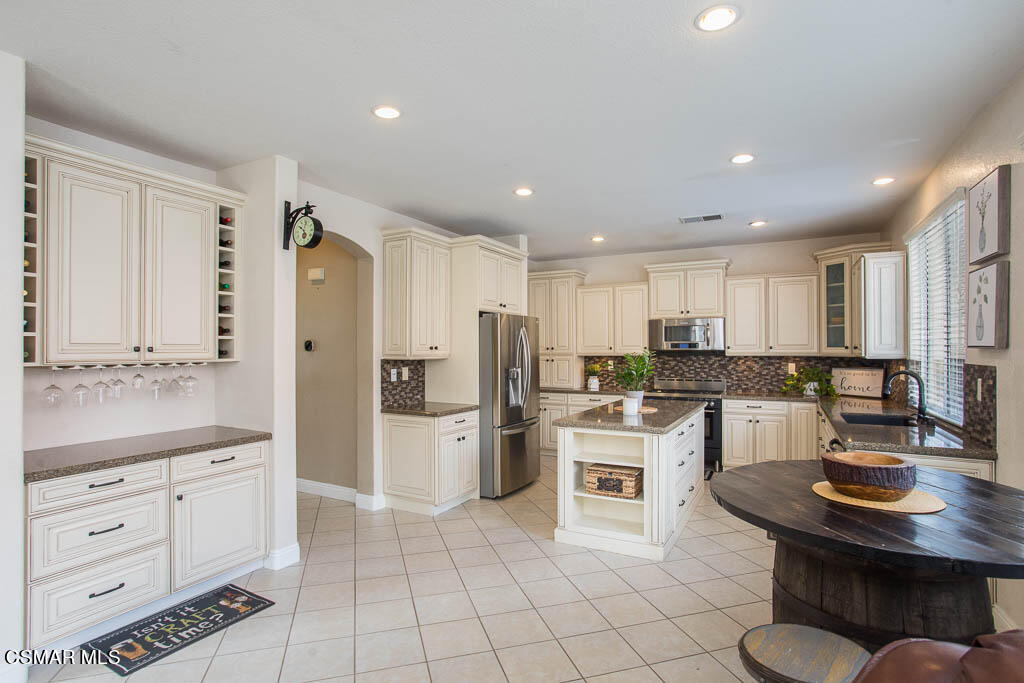 1902 Winterdew Avenue Simi Valley, CA 93065 - Photo 12 of 29 a kitchen with white cabinets and stainless steel appliances