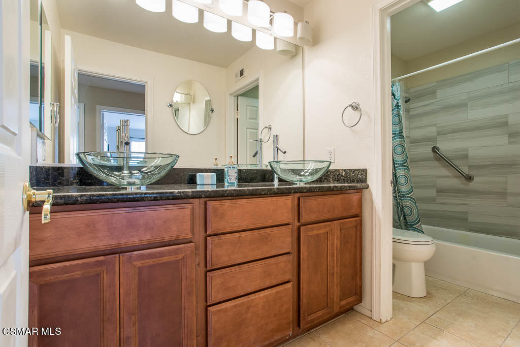 1902 Winterdew Avenue Simi Valley, CA 93065 - Photo 22 of 29 a bathroom with a granite countertop sink a toilet and a mirror