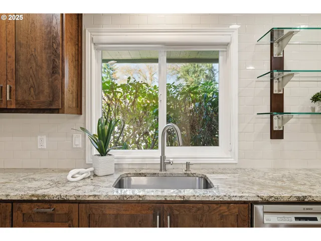 a kitchen with granite countertop a sink and a window