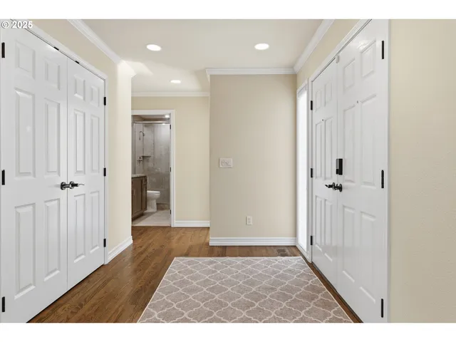 a view of a hallway with wooden floor and closet area
