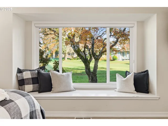 a bedroom with a large window and a bed