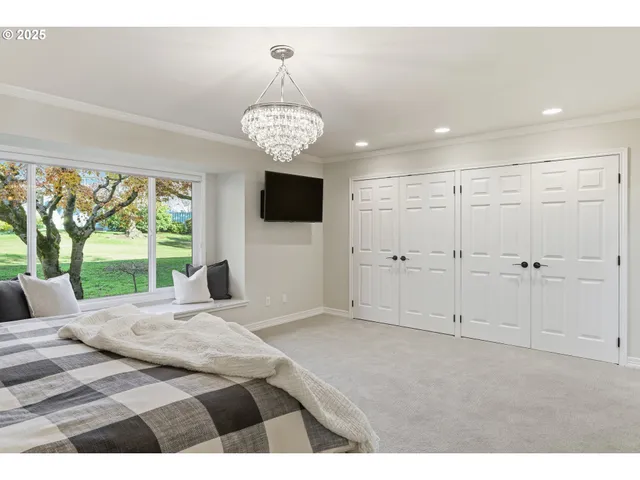 a view of a bedroom with a bed chandelier and a large window