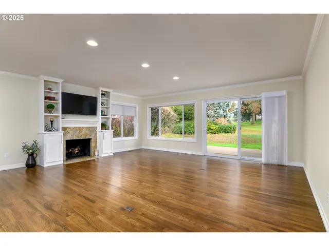 a view of empty room with a fireplace and wooden floor