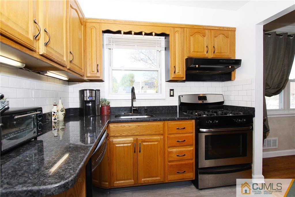 14 Wilshire Road Edison, NJ 08817 - Photo 8 of 22 a kitchen with stainless steel appliances granite countertop a stove a sink and a microwave