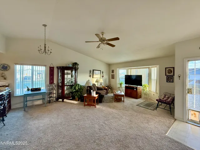 a living room with furniture two window and a flat screen tv