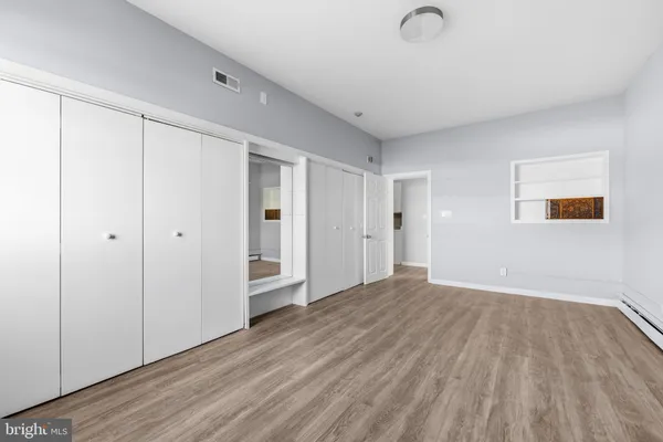 a view of an empty room with wooden floor