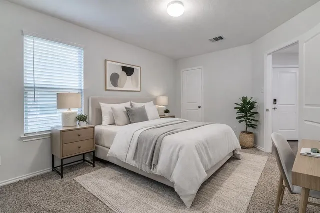 a bedroom with a bed and a potted plant
