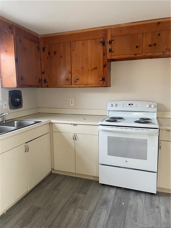a kitchen with cabinets appliances and wooden floor