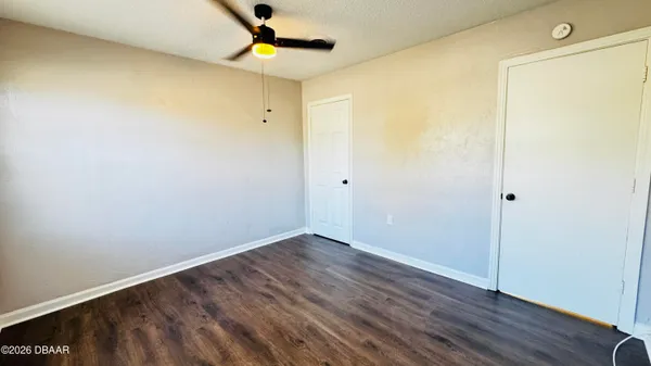 a view of empty room with wooden floor