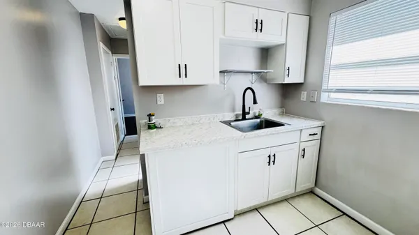 a kitchen with granite countertop white cabinets and white appliances