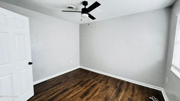 a view of a room with wooden floor and fan