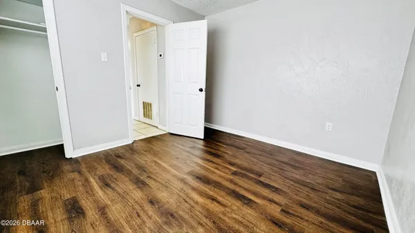 a view of an empty room with wooden floor