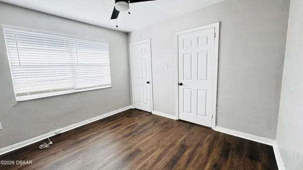 an empty room with wooden floor and windows