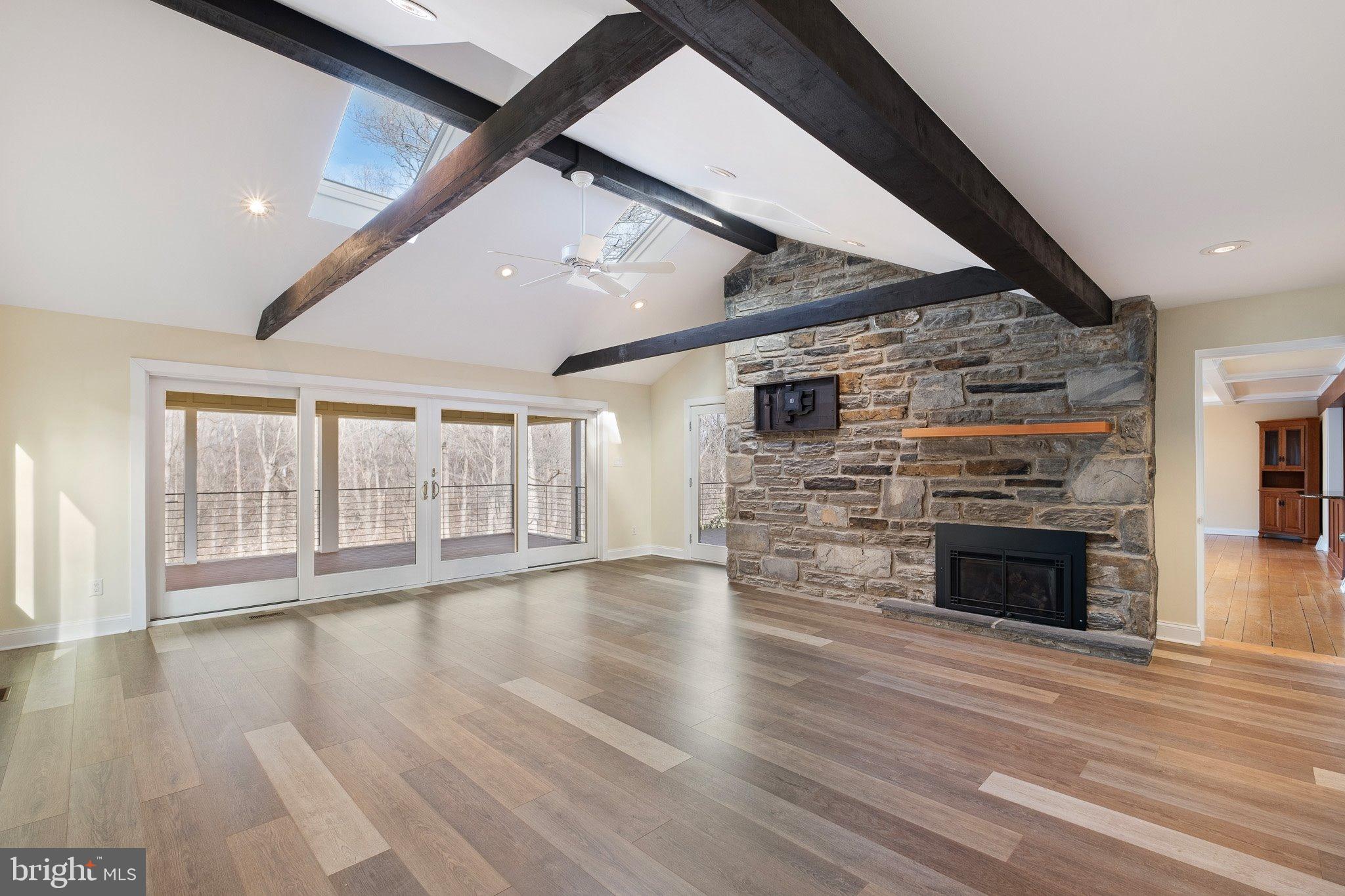 370 Marple Road Broomall, PA 19008 - Photo 27 of 46 an empty room with wooden floor fireplace and windows