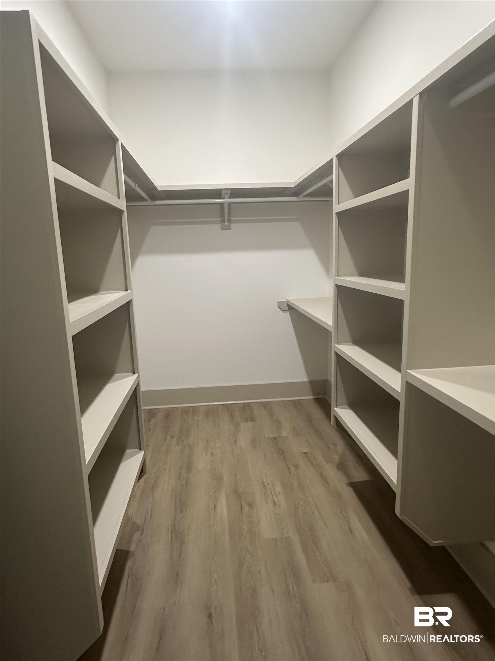 13111 Gopher Court Elberta, AL 36530 - Photo 23 of 41 Walk-in closet featuring built-in shelving, hanging rods, and wood-finish flooring
