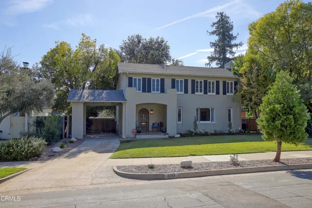 a view of a house with a big yard and large trees