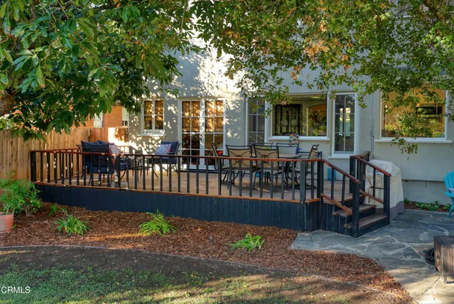 a view of a deck with a large window and wooden fence