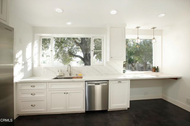 a kitchen with a sink window and cabinets