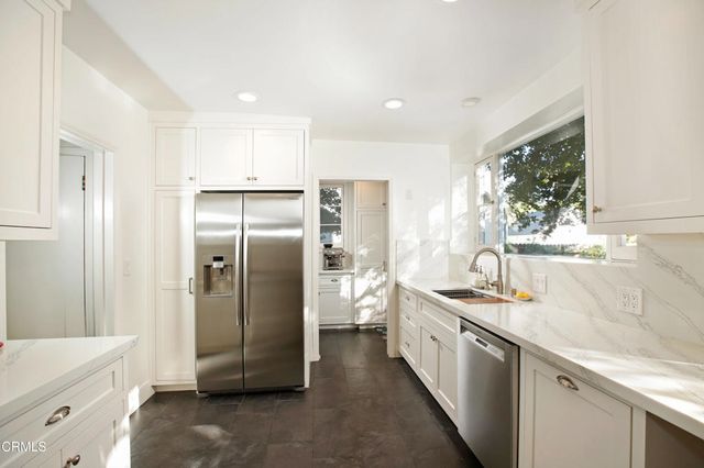 a kitchen with stainless steel appliances granite countertop a refrigerator and a sink