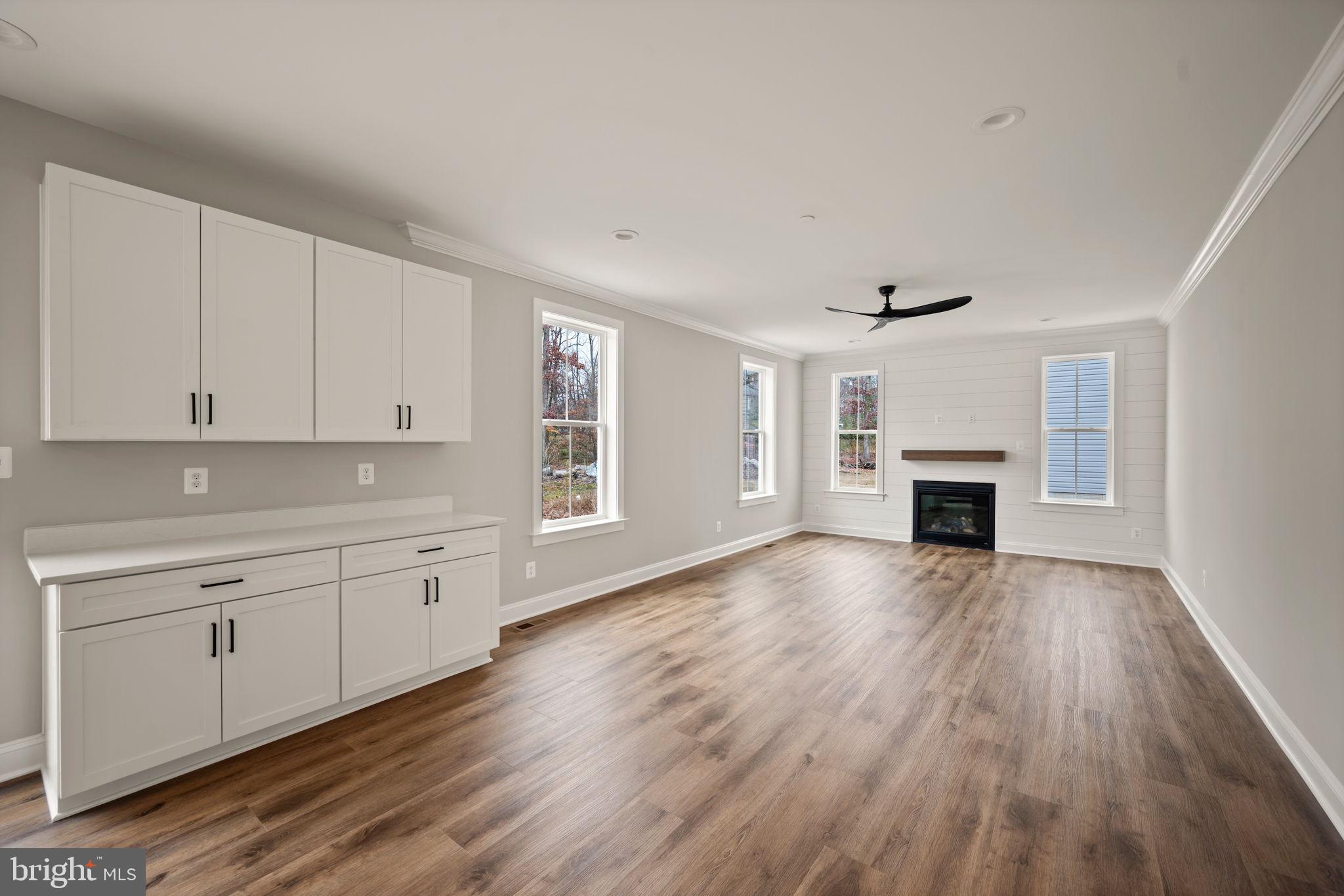 9436 Ridgely Avenue Baltimore, MD 21234 - Photo 14 of 44 a view of empty room with wooden floor and fireplace