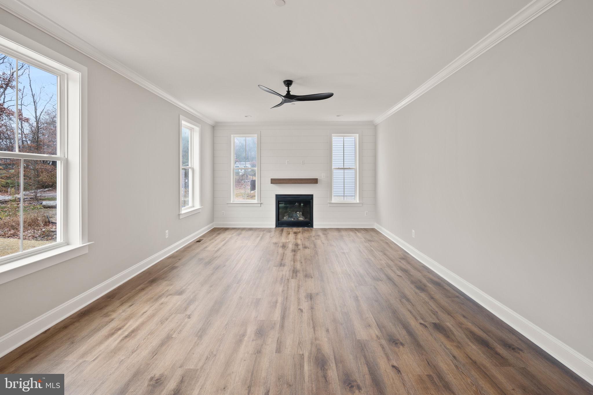 9436 Ridgely Avenue Baltimore, MD 21234 - Photo 15 of 44 wooden floor fireplace and windows in an empty room