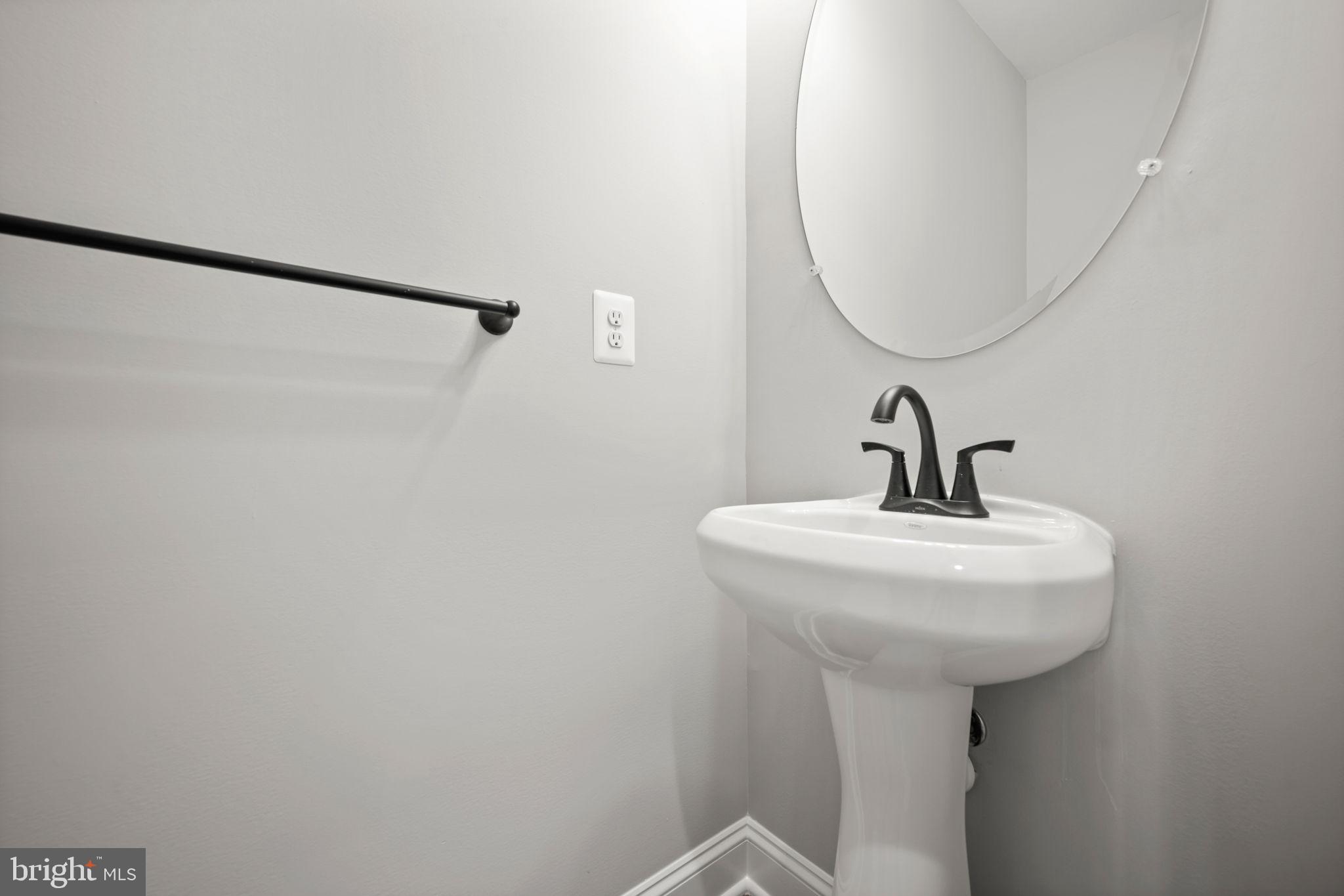 9436 Ridgely Avenue Baltimore, MD 21234 - Photo 17 of 44 a bathroom with a sink a mirror and shower