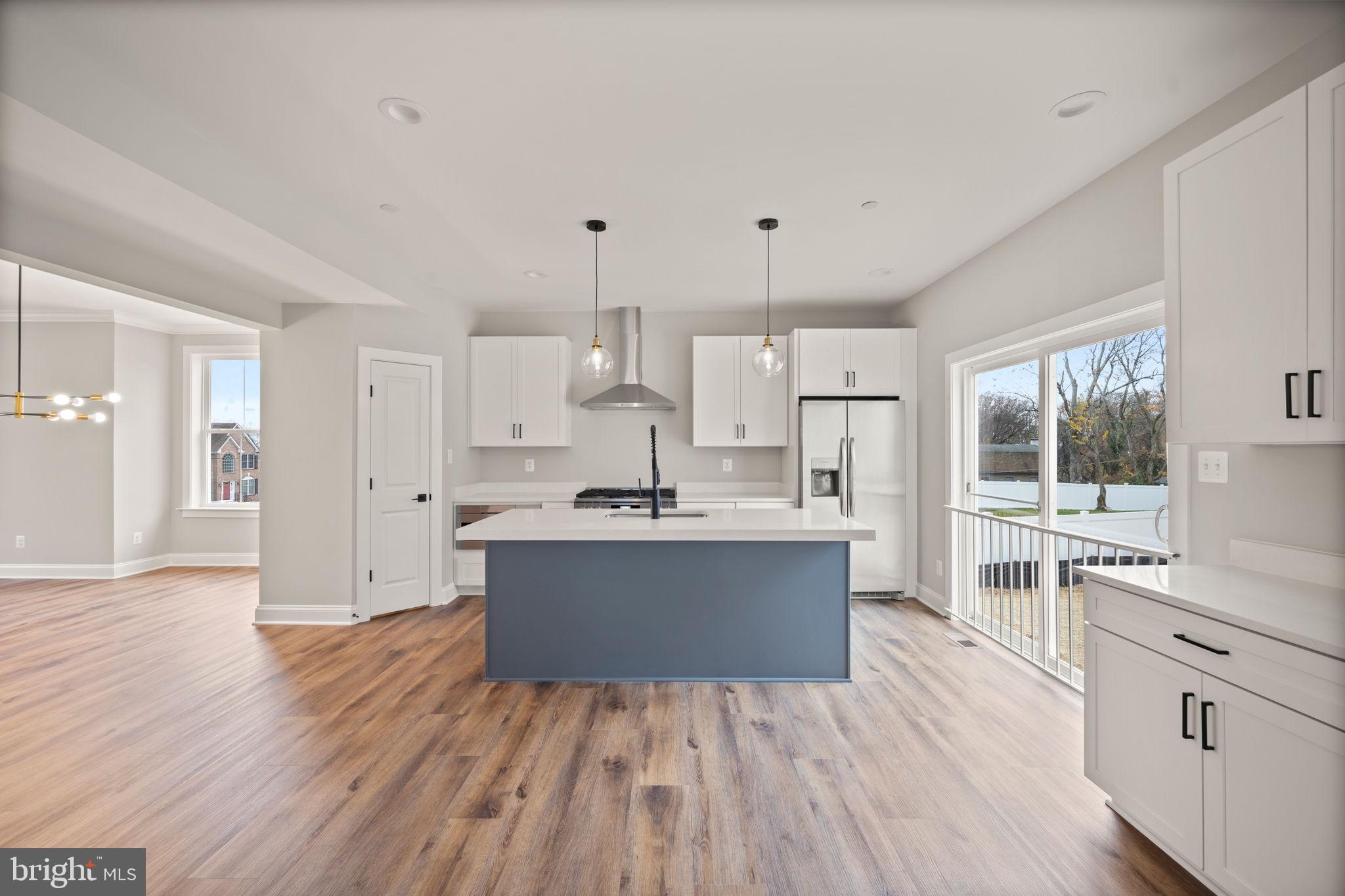 9436 Ridgely Avenue Baltimore, MD 21234 - Photo 8 of 44 a kitchen with stainless steel appliances kitchen island wooden floors and white cabinets