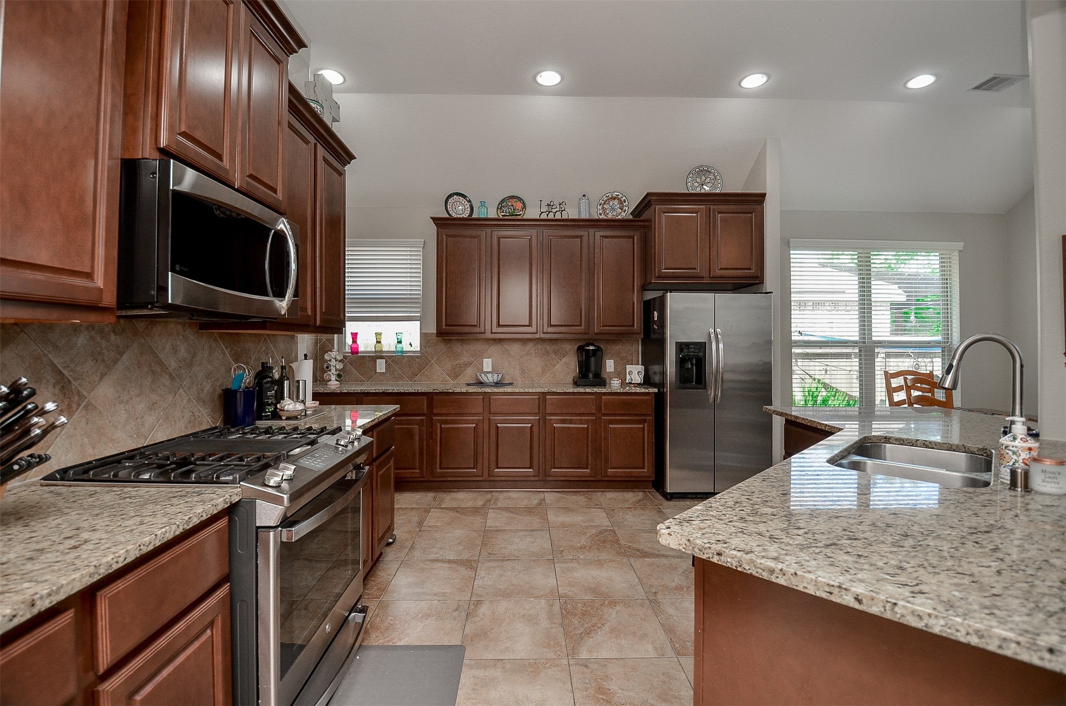 1310 Ellis Grove Lane Rosenberg, TX 77471 - Photo 15 of 38 a kitchen with stainless steel appliances granite countertop a sink a stove and a microwave