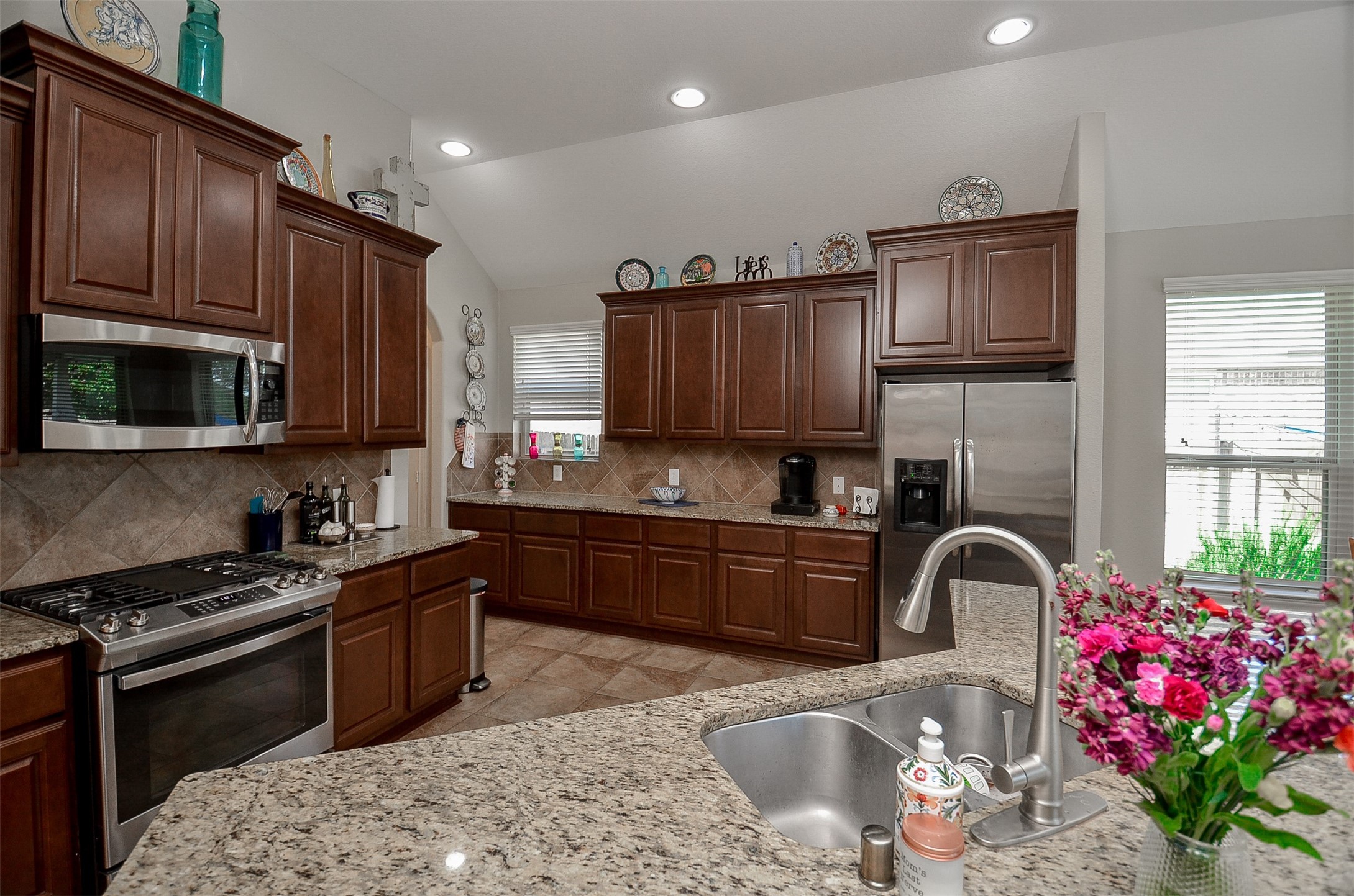 1310 Ellis Grove Lane Rosenberg, TX 77471 - Photo 16 of 38 a kitchen with granite countertop wooden cabinets stainless steel appliances and a window