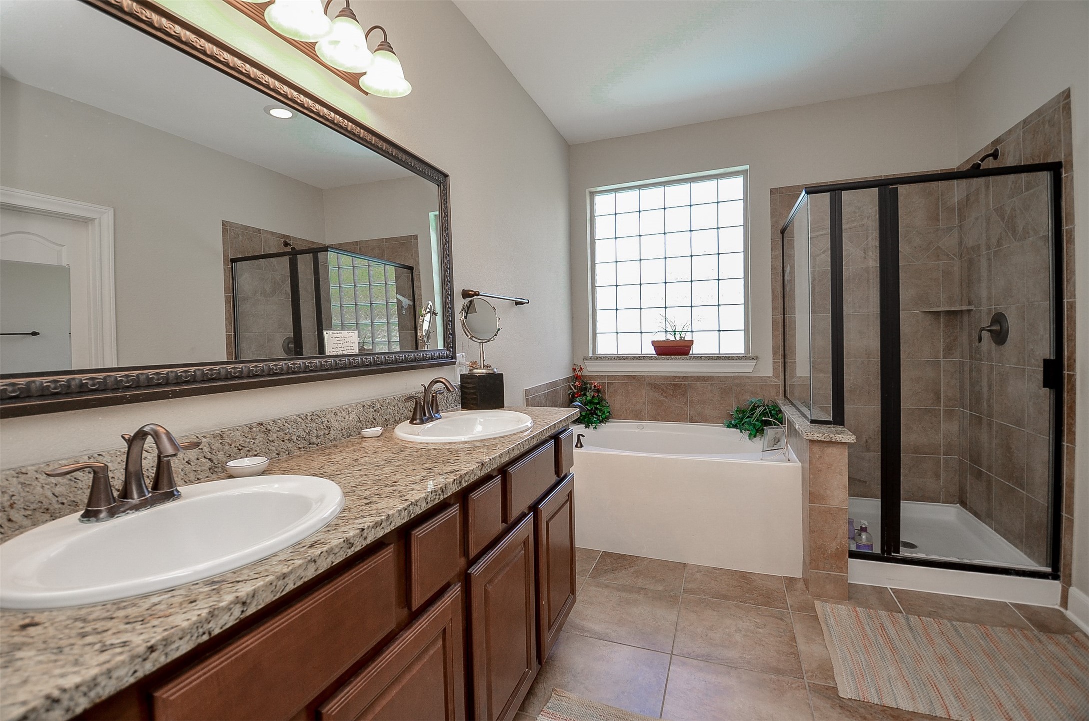 1310 Ellis Grove Lane Rosenberg, TX 77471 - Photo 20 of 38 a bathroom with a granite countertop double vanity sink a mirror and a bathtub