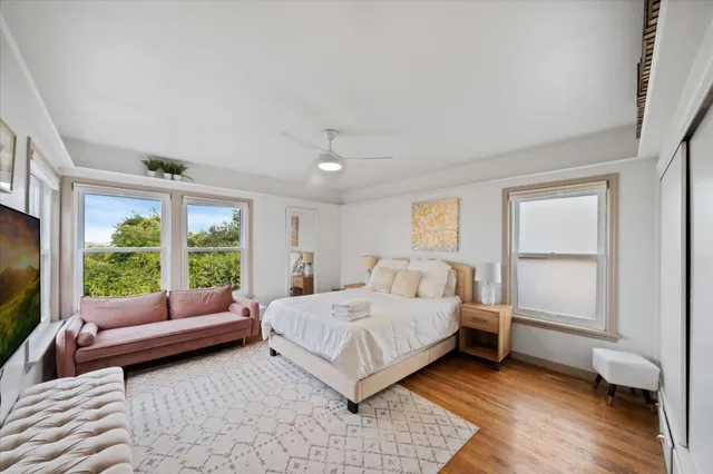 a bedroom with a bed couch and a large window