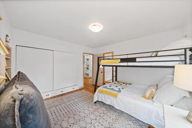 a bedroom with a bed and wooden floor