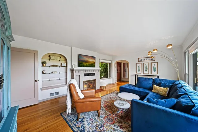 a living room with furniture a rug and a bookshelf