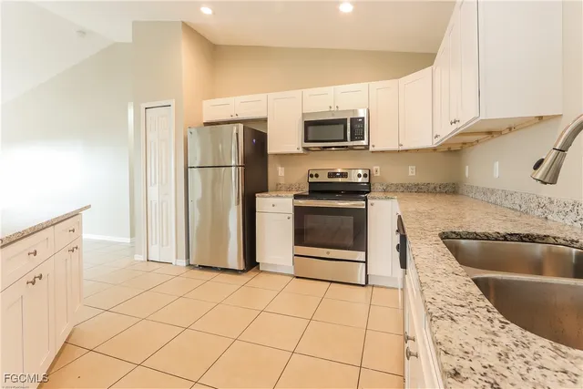 a kitchen with stainless steel appliances granite countertop a refrigerator sink and stove