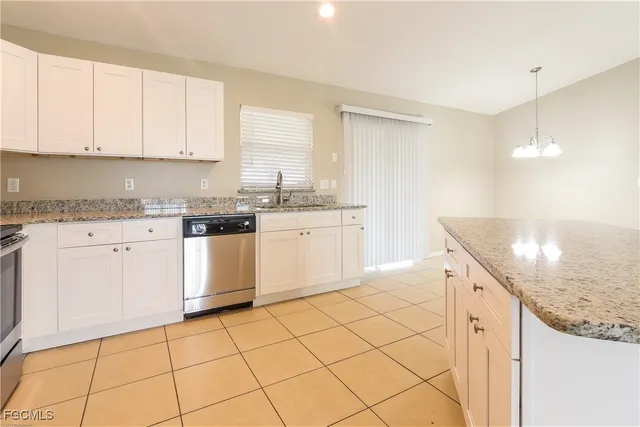 a kitchen with granite countertop white cabinets and white appliances