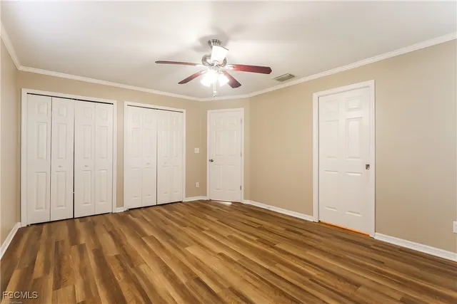 wooden floor in an empty room with a chandelier fan