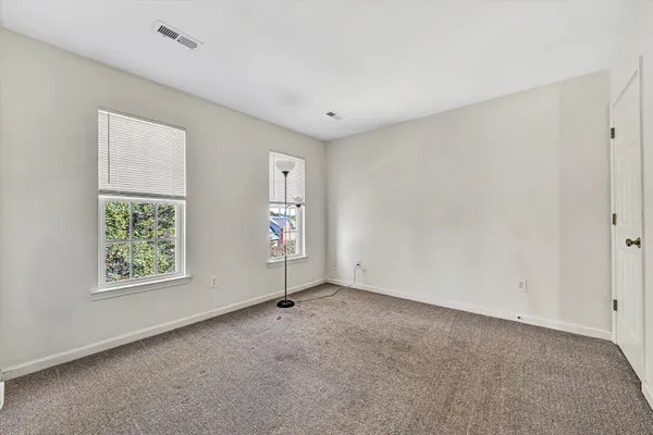 an empty room with wooden floor & closet area