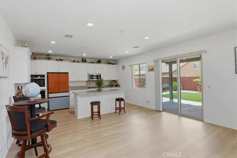 a living room with stainless steel appliances granite countertop furniture and wooden floor