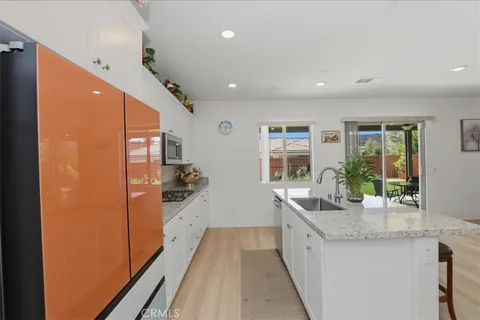 a large kitchen with stainless steel appliances granite countertop a lot of counter space and wooden floor