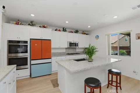 a kitchen with stainless steel appliances granite countertop a sink and a refrigerator