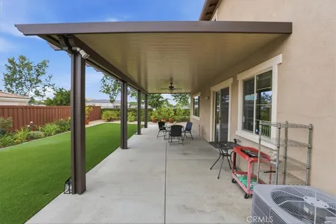 a view of a patio with table and chairs potted plants and floor to ceiling window