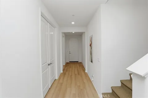 a view of a hallway with wooden floor and staircase