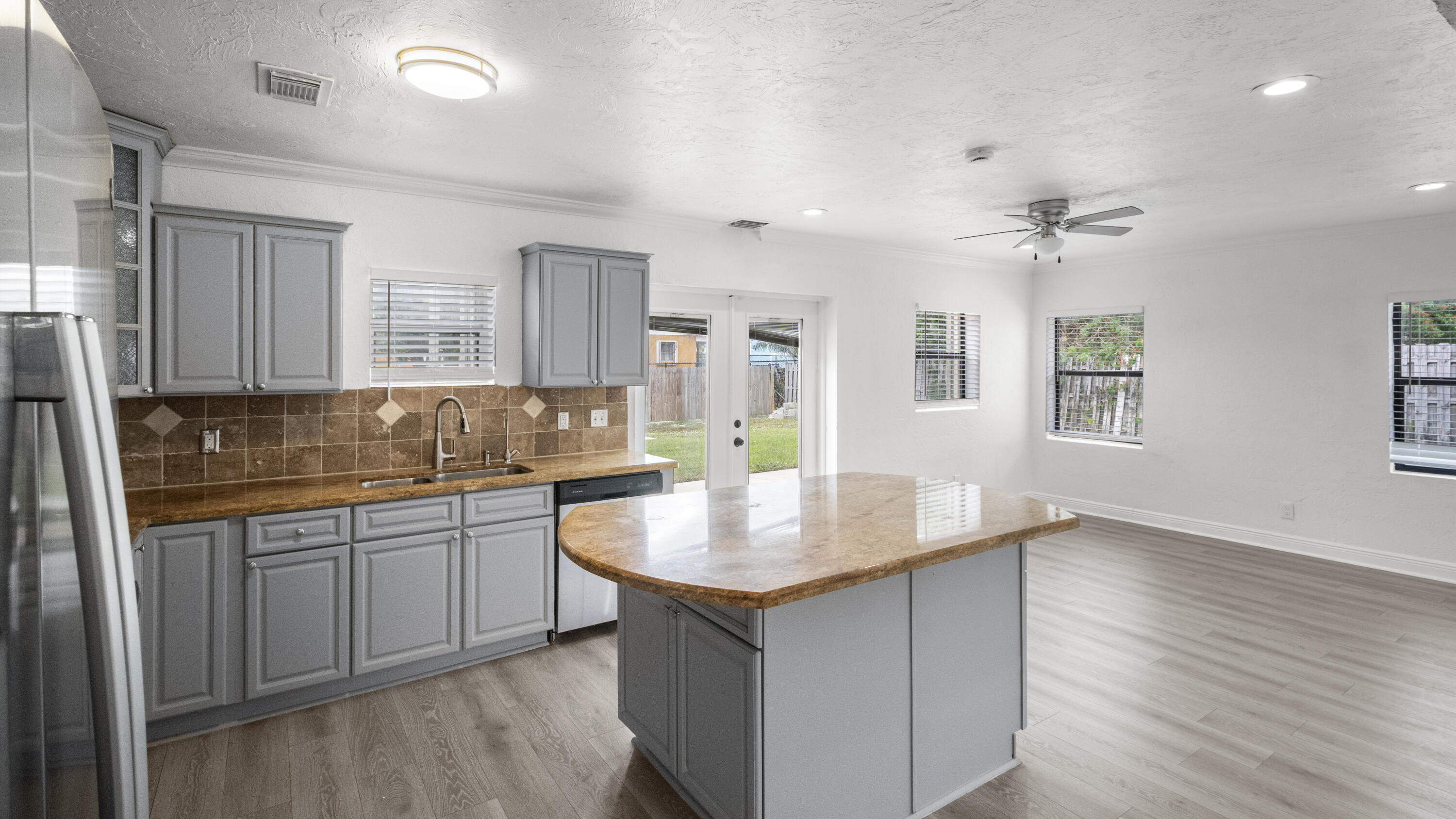 1233 West 32nd Street Riviera Beach, FL 33404 - Photo 12 of 25 a kitchen with granite countertop a sink cabinets and wooden floor