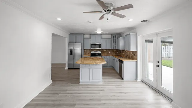 a view of a kitchen with cabinets stainless steel appliances and a window