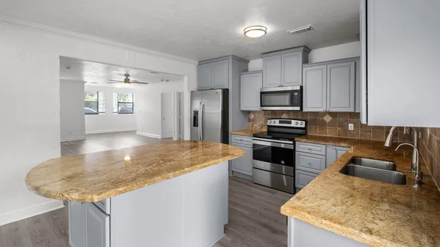 a kitchen with granite countertop a stove and a sink