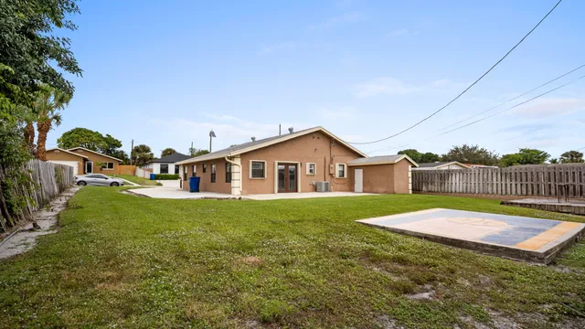 a house that is sitting in the grass with large trees