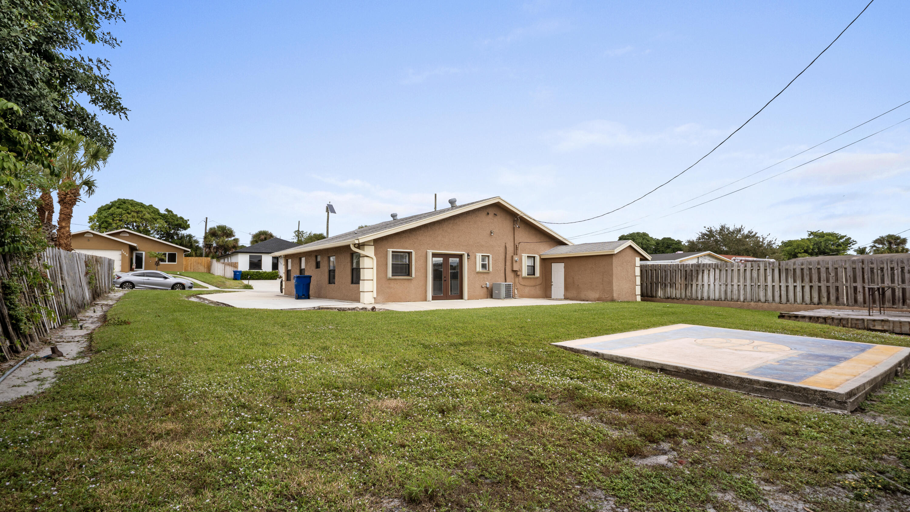 1233 West 32nd Street Riviera Beach, FL 33404 - Photo 24 of 25 a house that is sitting in the grass with large trees