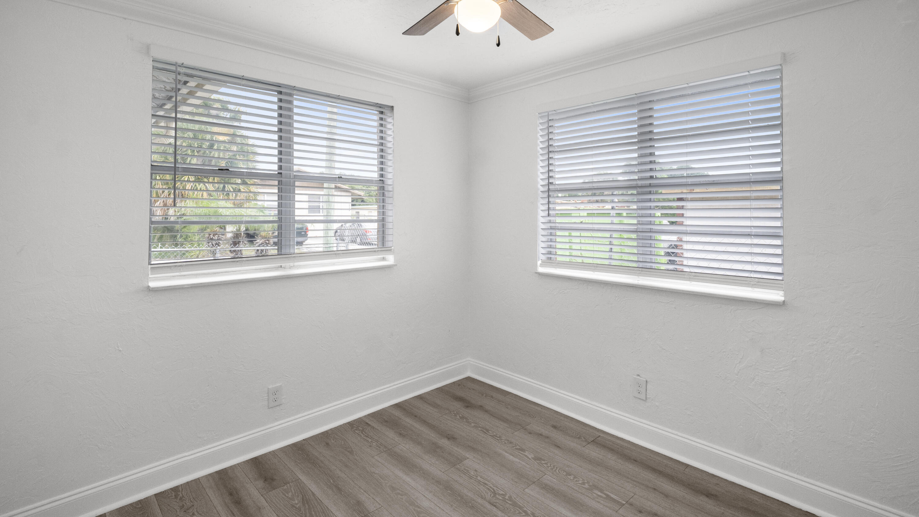 1233 West 32nd Street Riviera Beach, FL 33404 - Photo 5 of 25 a view of an empty room with wooden floor and a window