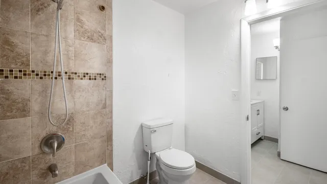a bathroom with a toilet and a shower