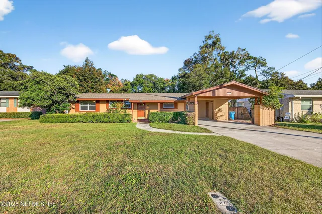 a front view of a house with yard and green space